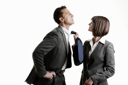 Businesswoman pulling her colleague from his tieの写真素材