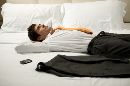Tired Businessman resting in hotel roomの写真素材