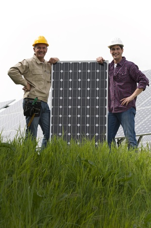 Technicians installing solar panelsの写真素材