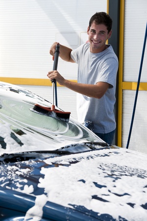 Young man washing his car with compression waterの写真素材