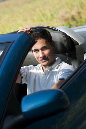 Front view of a young man driving his convertible car