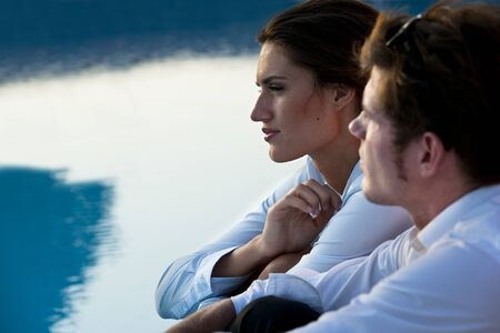 Young couple or businsspeople relaxing by pool