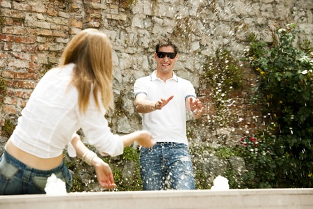 Young couple playing with waterの写真素材
