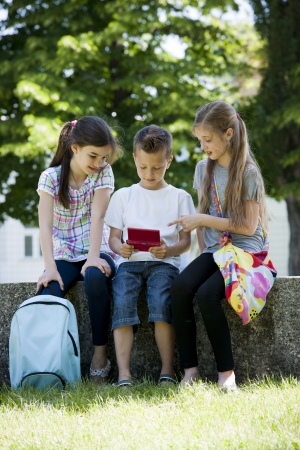 Children playing video games outdoorsの写真素材