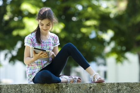 Little girl using PC tablet outdoorsの写真素材