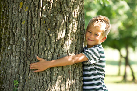 Little boy hugging a tree. Concept: care of natureの写真素材