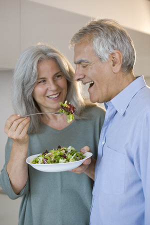 Happy senior couple eating a saladの写真素材