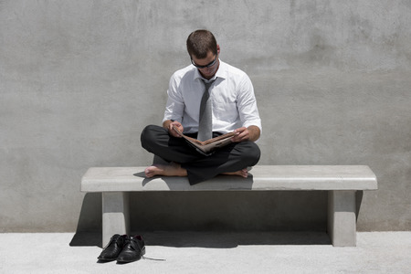 Relaxed businessman reading outdoorsの写真素材