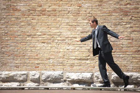 Businessman trying to keep his balanceの写真素材