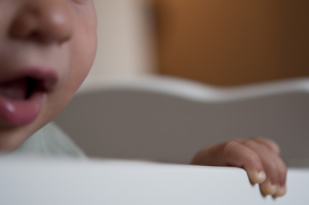 Close-up of a little Baby bitting on cribの写真素材