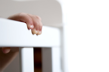 Close-up of baby hand on cribの写真素材