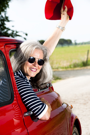 Senior happy woman with vintage carの写真素材