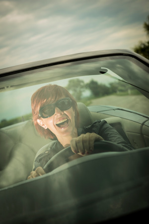 Excited woman enjoying driving her convertible carの写真素材