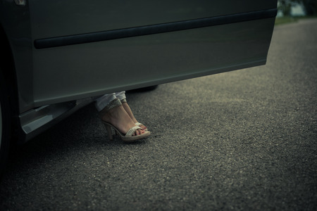 Woman legs next to carの写真素材
