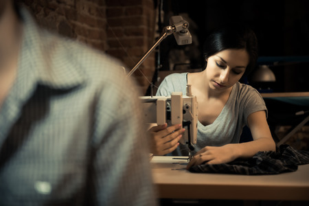 Young woman working on sewing machineの写真素材