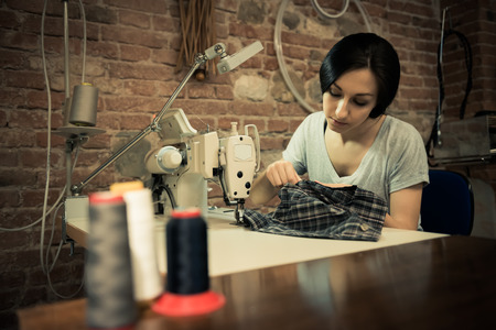 Young woman working on sewing machineの写真素材
