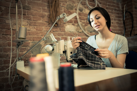 Young woman working on sewing machineの写真素材