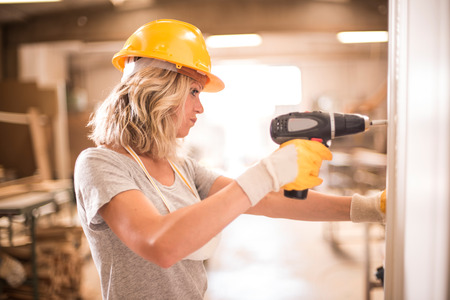 Female carpenter using screwdriverの写真素材