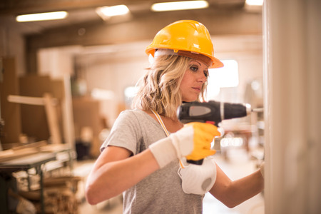 Female carpenter using screwdriverの写真素材