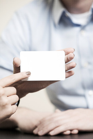 business card blank and white, woman is holding it with her fingersの写真素材