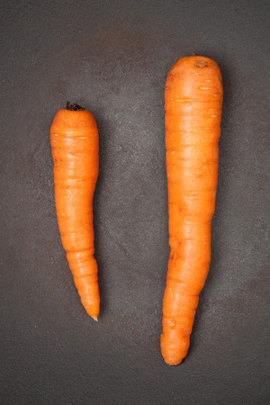 Two orange carrots in a wok, close upの写真素材