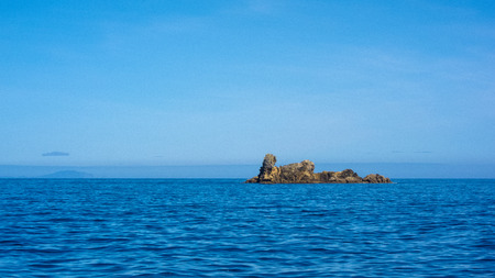 small island in blue waterの写真素材