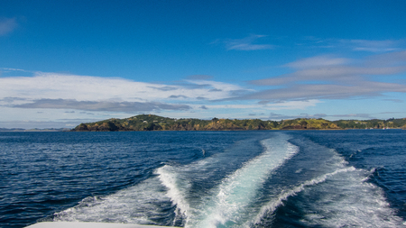white foam from a boat in blue waterの写真素材