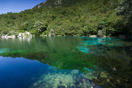 The emerald waters of Lake Cornino in the Cornino regional nature reserve, Italyの写真素材