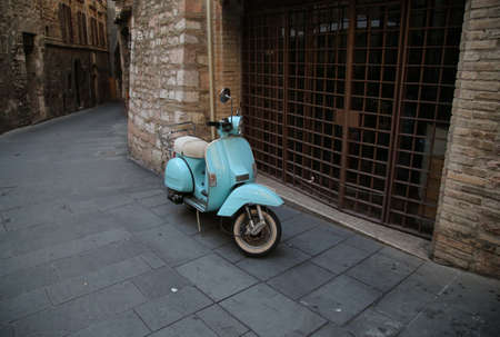An old scooter in a street of Assisi, Italyの写真素材
