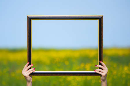 Picture frame with yellow field in background.