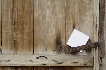Old door with a white sheet of paperの写真素材