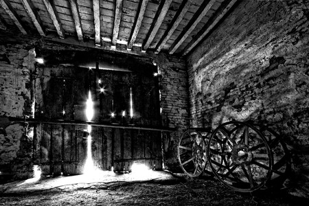 A very old doorway with 2 old wheels tractorの写真素材