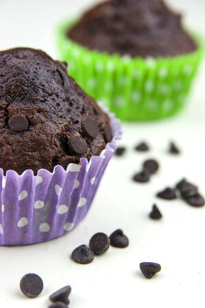 Close up of chocolate muffins on a white table with a lot of chocolate's dropsの写真素材