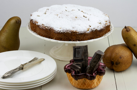 Italian cake with ricotta, pears and drops of chocolate on white and wooden table.の写真素材