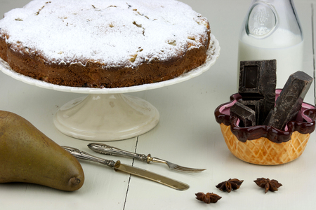 Italian cake with ricotta, pears and drops of chocolate on white and wooden table.の写真素材