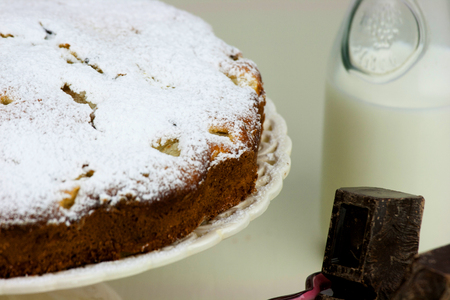 Italian cake with ricotta, pears and drops of chocolate on white and wooden table.の写真素材