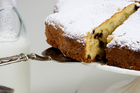 Italian cake with ricotta, pears and drops of chocolate on white and wooden table.の写真素材