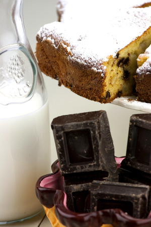 Italian cake with ricotta, pears and drops of chocolate on white and wooden table.の写真素材