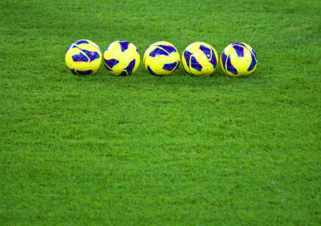 Five yellow and blue balls on the soccer