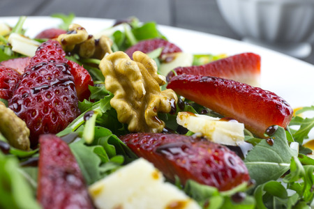 Spring salad with strawberries, rocket salad, parmesan cheese, walnuts and balsamic vinegar.の写真素材