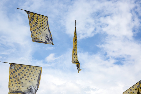 Traditional italian festival with flag throwers.Flags on the blue sky.の写真素材