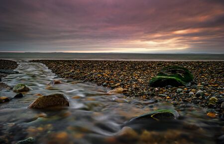 The Junction: full of courage, this Little Stream runs foolishly towards the shore and tries to fight against the Sea coming back to the lands at rising tide! Gyles Quay, Dundalk, Louth, Irelandの写真素材
