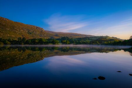 Giant mirror: as every passing morning, this mountain gets up and watches itself in the Mirror, Gougane Barra, County Cork, Ireland.の写真素材
