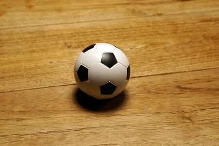 White and black mini football at wooden tableの写真素材
