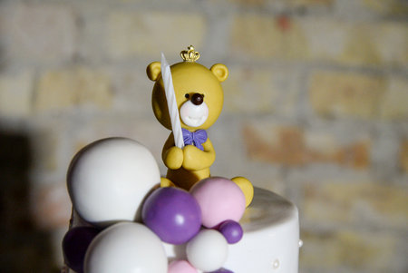 A three-tier white birthday cake decorated with yellow teddy bears.の写真素材
