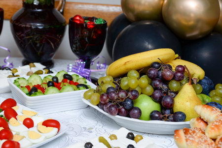 A plate with pears, bananas and grapes placed on the table as a dessert after the main courseの写真素材