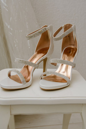 Elegant open luxury women's shoes with zircons and in the background lace from a wedding dressの写真素材