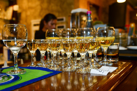 Glasses with various types of drinks are lined up on the bar as a pre-meal appetizer in the restaurantの写真素材