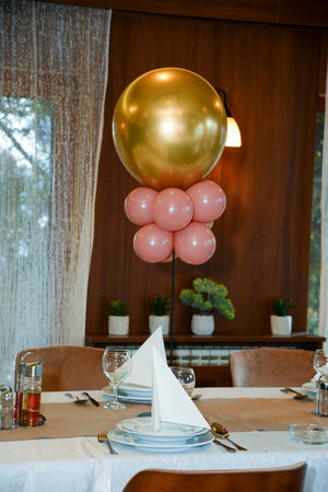Pink and gold balloons as decoration on the tables in the restaurantの写真素材