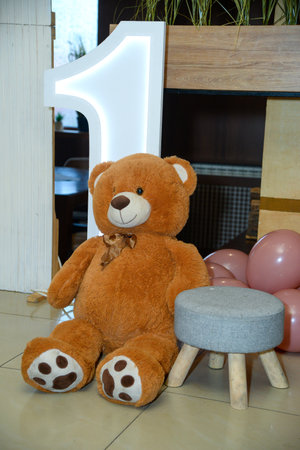 Various colorful balloons, neon number one, big brown bear and neon letters that say number one as a birthday decorationの写真素材